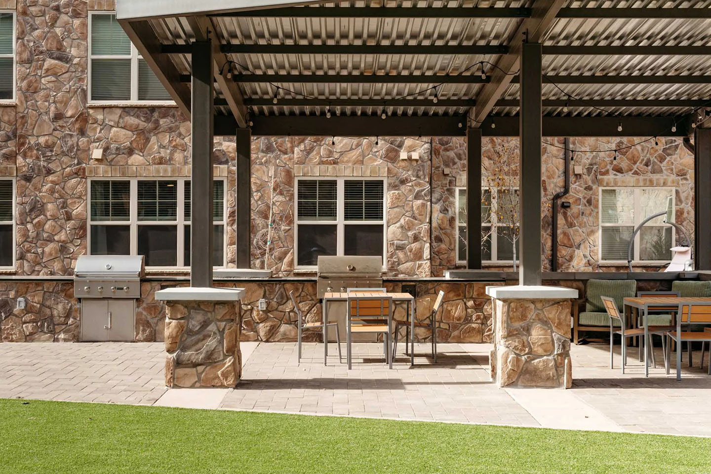 Shaded outside area with tables and grills.